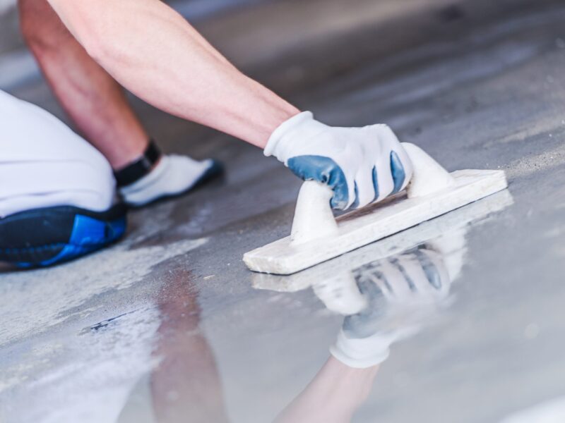 Concrete Floor Building Concrete Floor Building. Watering and Leveling Floor Surface. House Construction Concept.